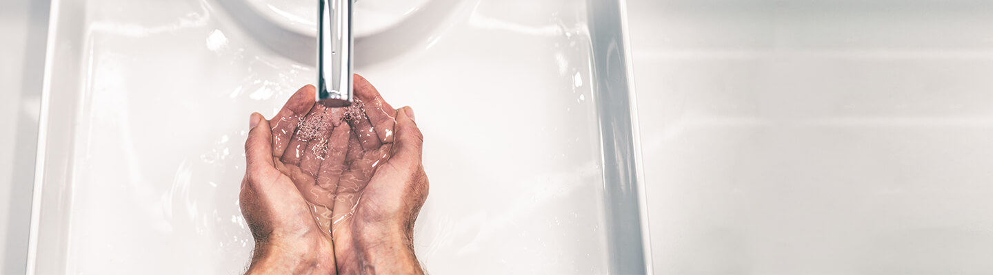 Wide angle of hands under tap