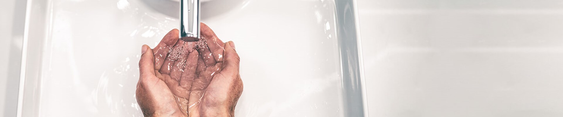 Wide angle of hands under tap