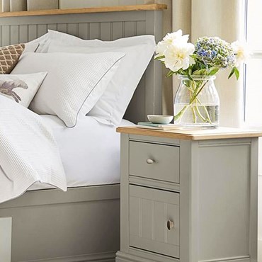 Bedside table in sage next to white bed sheets