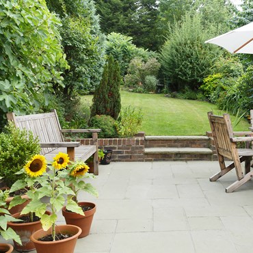 Outdoor patio with wooden furniture and sunflowers