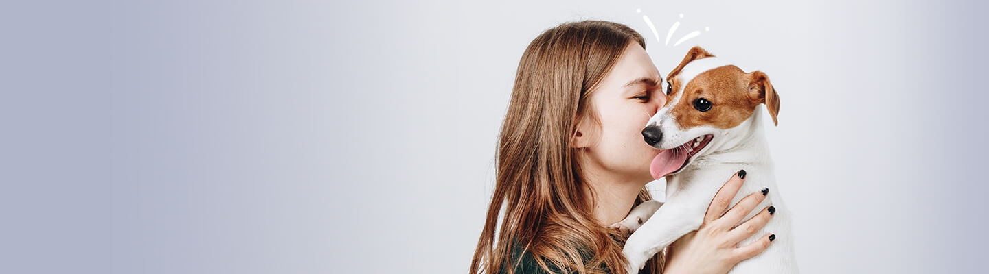 Woman kissing her dog wide angle