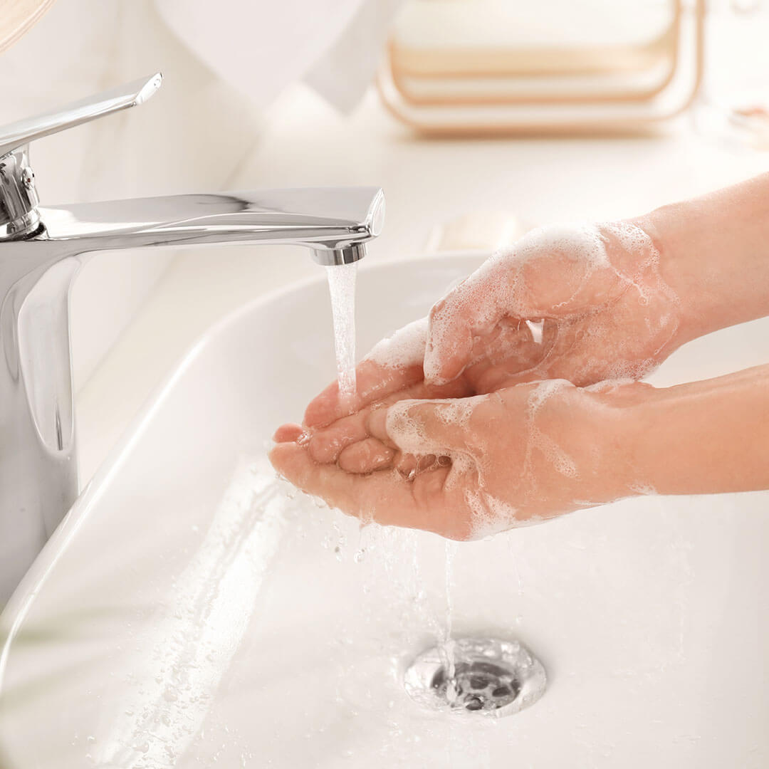 Person washing their hands with soap and water