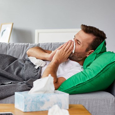 Man blowing nose with tissues