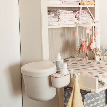 Nappy bin next to baby changing table